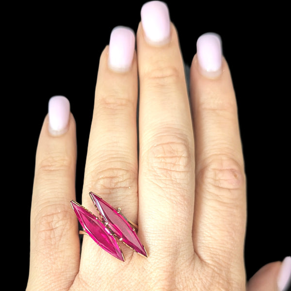 Hand wearing a pink ring with a black background