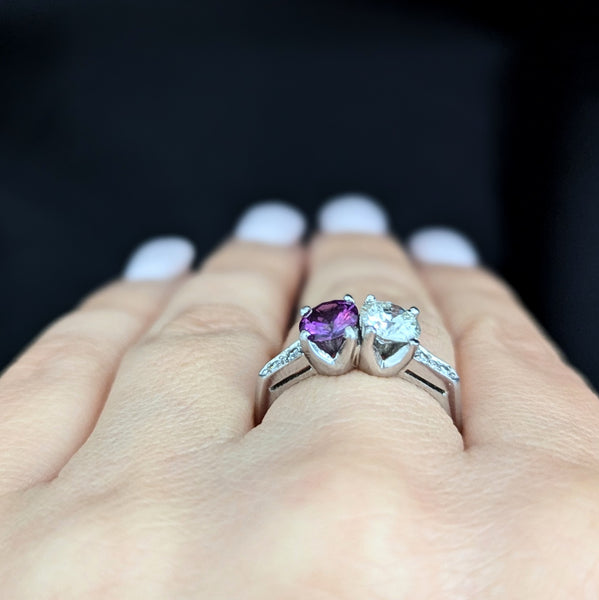 This exquisite vintage toi et moi ring beautifully captures the romanticism of the classic two-stone design, a symbol of two souls intertwined. The ring showcases an old European cut diamond paired with a lovely purplish- pink sapphire. Toi et moi jewelry, historically popularized in the 18th and 19th centuries, gained significant prominence when Napoleon Bonaparte gifted Josephine a similar ring, forever embedding this style in the narrative of love and partnership. Today, this design is a popular choice f