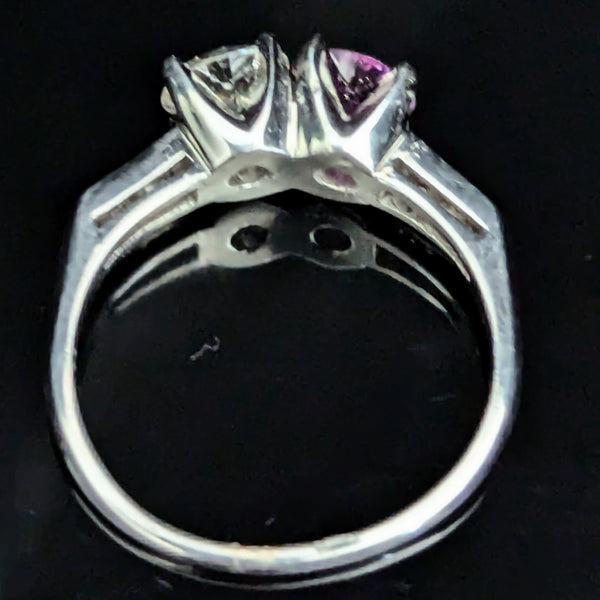 This exquisite vintage toi et moi ring beautifully captures the romanticism of the classic two-stone design, a symbol of two souls intertwined. The ring showcases an old European cut diamond paired with a lovely purplish- pink sapphire. Toi et moi jewelry, historically popularized in the 18th and 19th centuries, gained significant prominence when Napoleon Bonaparte gifted Josephine a similar ring, forever embedding this style in the narrative of love and partnership. Today, this design is a popular choice f