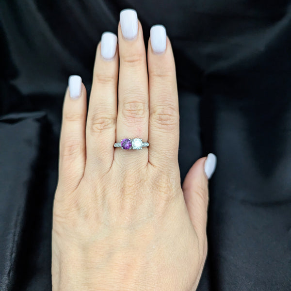 This exquisite vintage toi et moi ring beautifully captures the romanticism of the classic two-stone design, a symbol of two souls intertwined. The ring showcases an old European cut diamond paired with a lovely purplish- pink sapphire. Toi et moi jewelry, historically popularized in the 18th and 19th centuries, gained significant prominence when Napoleon Bonaparte gifted Josephine a similar ring, forever embedding this style in the narrative of love and partnership. Today, this design is a popular choice f