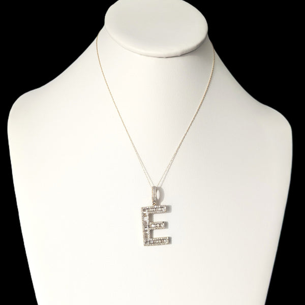 Necklace with a letter 'E' pendant on a mannequin bust against a black background