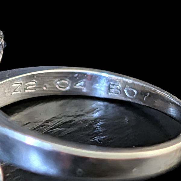 Close-up of the inside of a polished silver ring band, showing engraved metal purity markings '72.04' and '801' on a black background.
